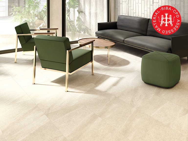 amtico flooring in open seating area with green and black seating with a circle table.