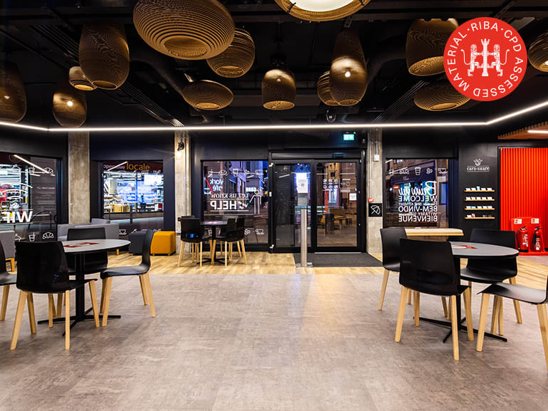 Three circular tables with chairs on Amtico flooring in a commercial space