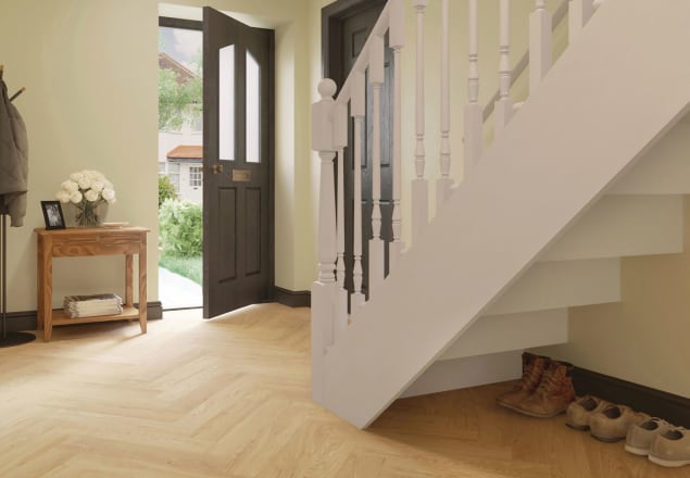 Sandy-coloured wood-effect floor planks in a parquet laying pattern in a hallway